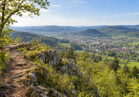 Sentier de randonnée et panorama lumineux sur les collines du Jura depuis le Mont Rivel.
